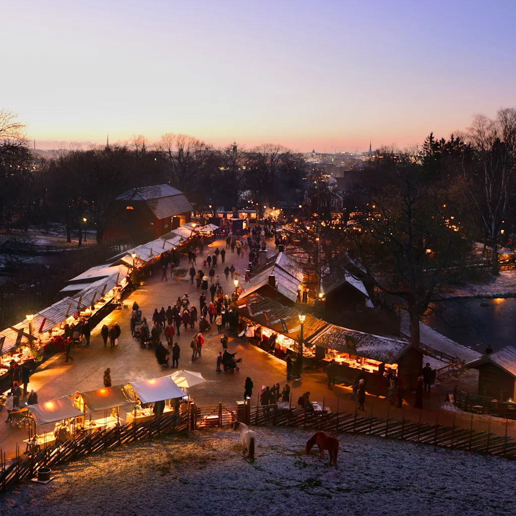Stemningsfuldt julemarked i skumringen med sne og varme lys. Foto credd Richard von Hofsten