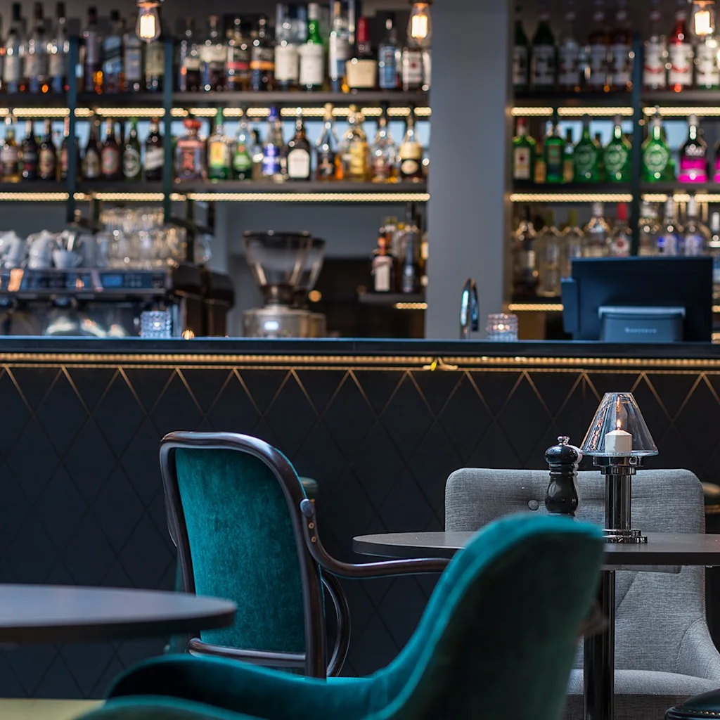 En hyggelig quality hotel ekoxen bar med en velassorteret disk, indbydende siddepladser og varm belysning, perfekt til afslapning.