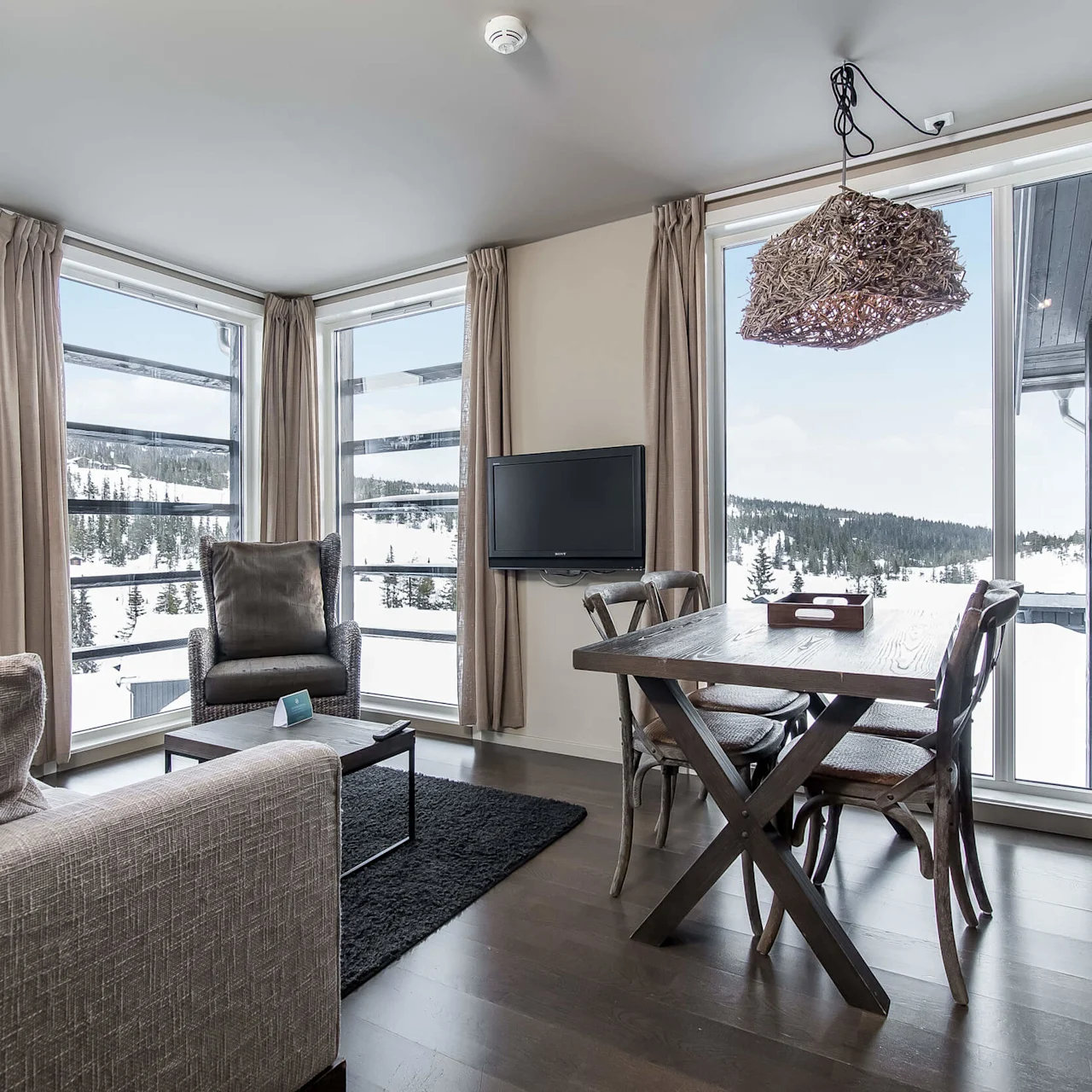 An apartment livingroom area with dining table, sofa an astonishing view of the mountain at Norefjell Ski & Spa in the Norwegian ski town of Norefjell.