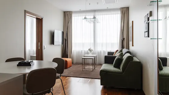 Valoisa ja kutsuva hotellisviitti, jossa on mukava oleskelutila, ruokailutila ja suuret ikkunat tuovat luonnonvaloa.