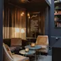 Et hyggeligt loungeområde med varm belysning og komfortable siddepladser. Et skilt lyder: Sulten? Godt, på den anden side af lobbyen har vi åbnet væggen lige ind til restauranten.