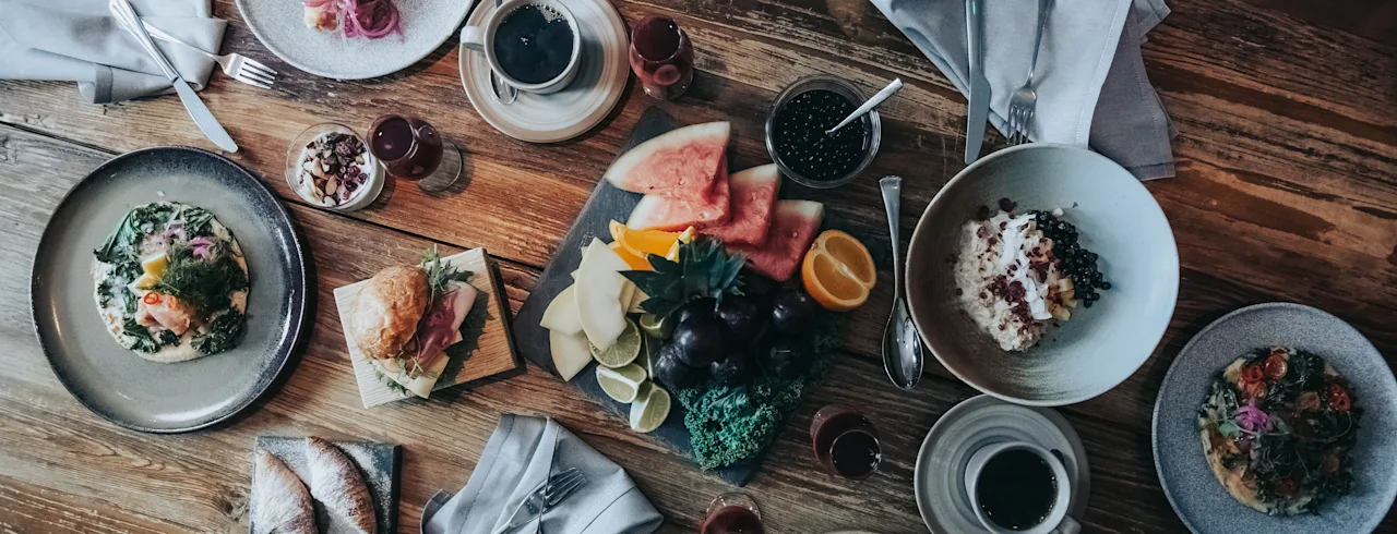En härlig och varierad frukost- eller brunchbuffé konstfullt arrangerad på ett rustikt träbord, redo att avnjutas.