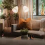 A warm and inviting living space featuring a comfortable sofa with pillows and a throw, illuminated by a stylish floor lamp.