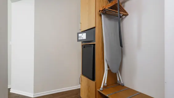 Comfort Hotel Linköping City. Hotellin vaatekaappi, jossa tallelokero, minijääkaappi, silityslauta ja henkarit vieraiden mukavuutta varten.