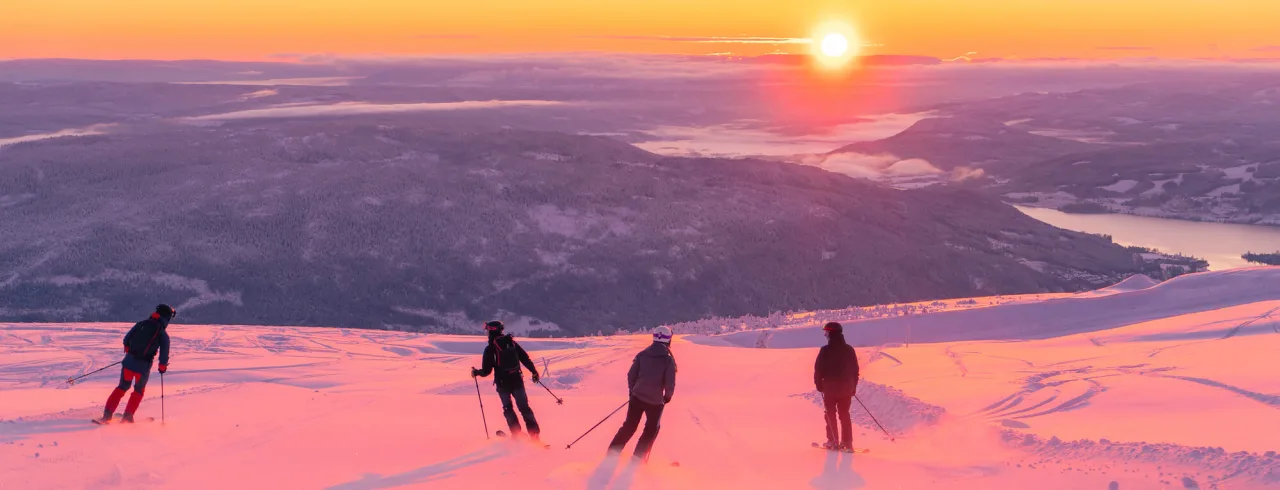 Skigåere nyter solnedgangen i slalombakken i Norefjell.