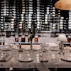 Jørgensens Hotel – Restaurant Eydes – Wine bar. An elegant table set for a meal, with a grand wine collection.