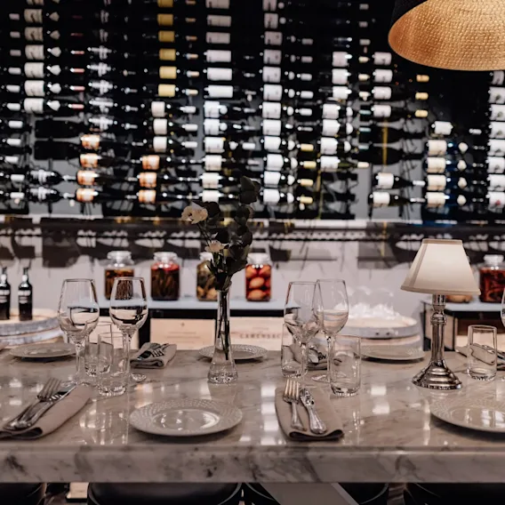 Jørgensens Hotel – Restaurant Eydes – Vinbar. Et elegant dækket bord til et måltid, med en stor vinsamling.