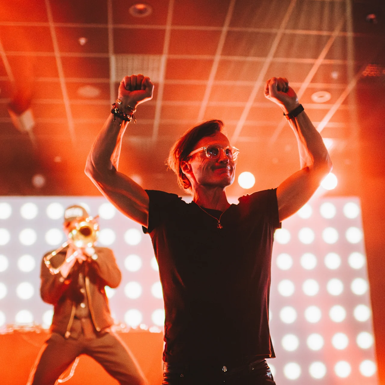 Petter Stordalen på scenen på Clarion Hotel Umeå feirer med løftede knyttnever under en konsert.