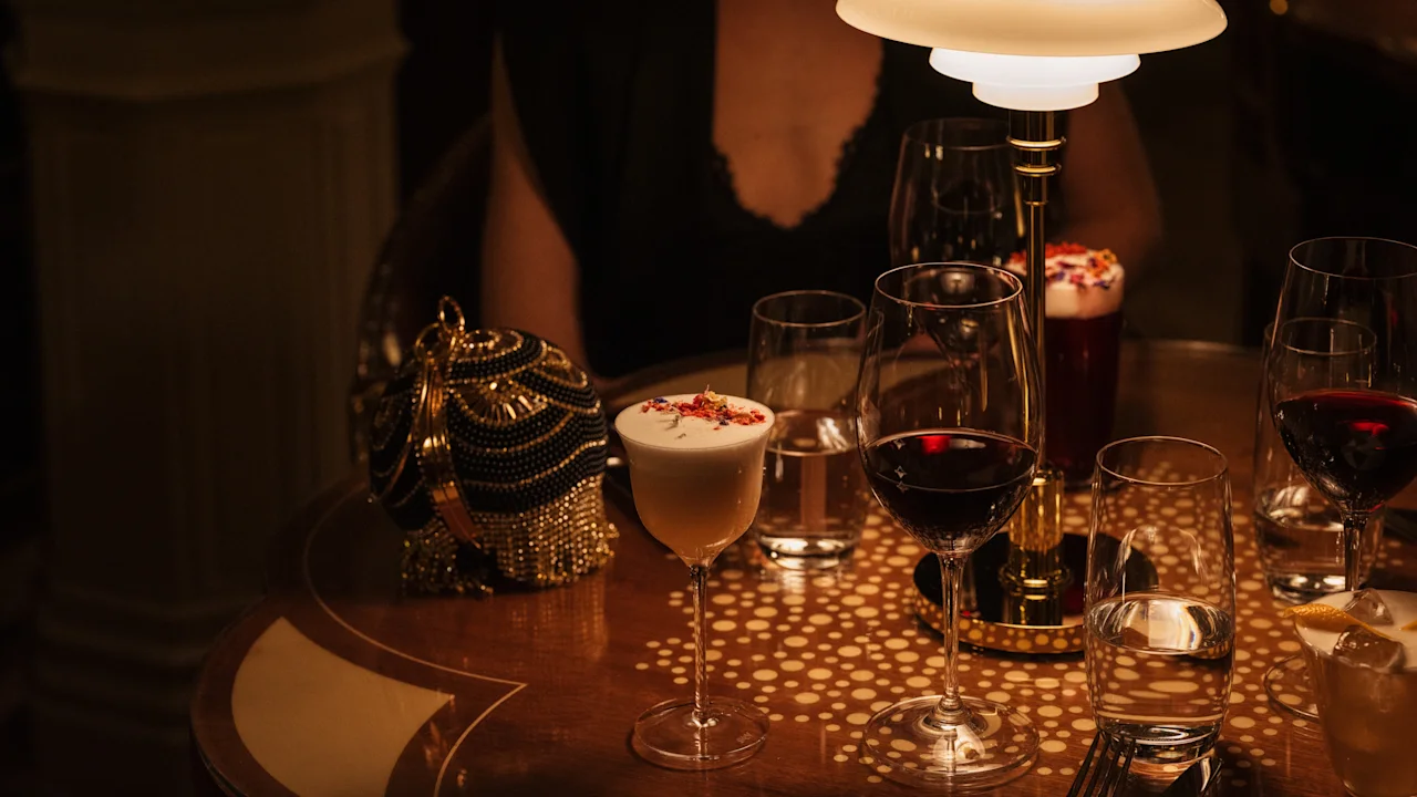 A cozy evening at Hotel Kämp – Kämp Bar, with various drinks on a patterned table under warm lighting.