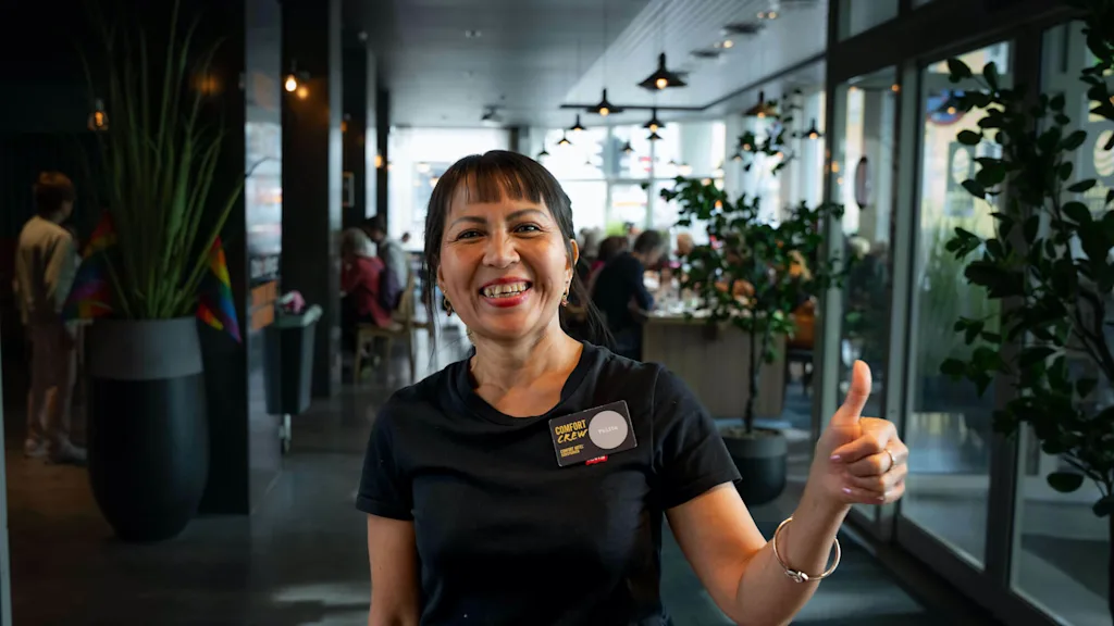 Employee at Comfort Hotel smiling while giving a thumbs up.