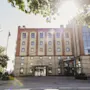Suuri tiilirakennus, jossa on paljon ikkunoita ja kaksi sisäänkäyntiä, Magasinet ja Hamngatan 9, kirkkaan taivaan alla.