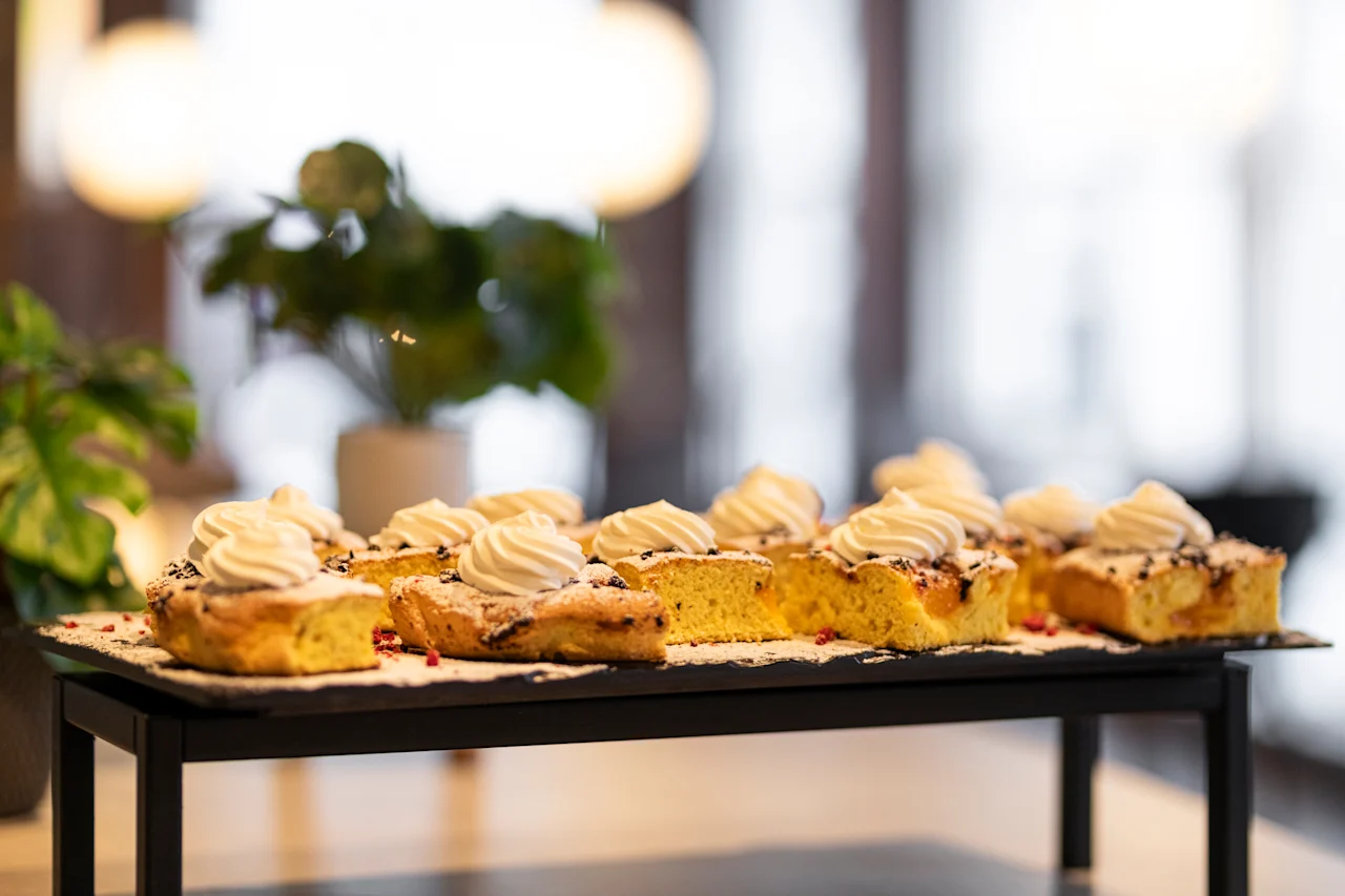 Delicious individual cake slices topped with whipped cream and powdered sugar, ready to be enjoyed in a bright setting.