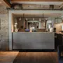 Et indbydende hotelreceptionsområde med en moderne disk, computere og en bar, med rustikke trævægge og synlige bjælker.