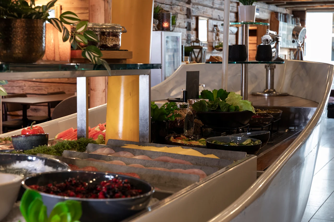En levende buffet med frisk frugt, bær og salater, præsenteret i et varmt og indbydende spisemiljø.