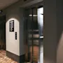En godt opplyst heislobby på et hotell, med en åpen heis og en etasjekatalog. Tekst: 1 Resepsjon, 2-7 Konferanse, 8 Treningsstudio, 9 Takterrasse.