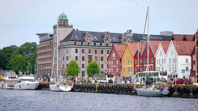 Scenic harbor view with historic colorful wooden buildings and boats docked along the waterfront.