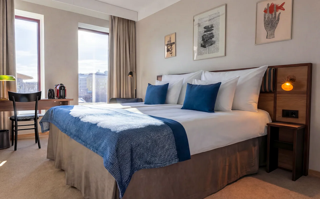 A bright and inviting hotel room at Quality Hotel The Book in Gothenburg, featuring a comfortable bed, desk, and city views.