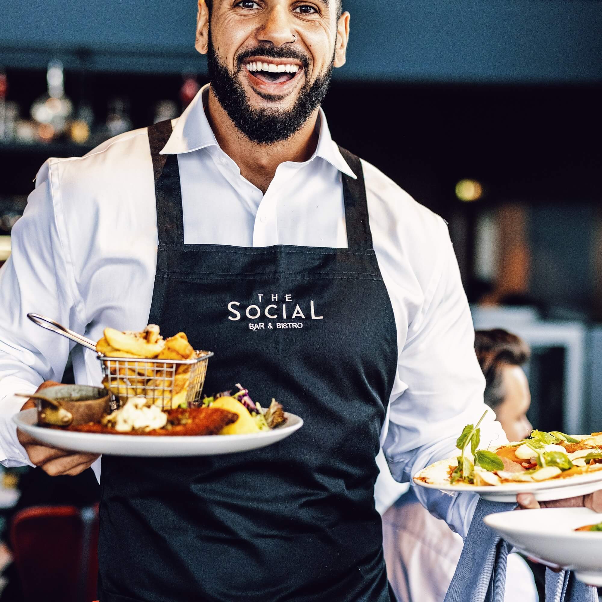 Man serving food at The Social Bar & Bistro.