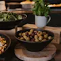 A vibrant buffet spread at Home Hotel Uppsala featuring fresh broccoli, a colorful chickpea salad, and a bowl of mixed olives.