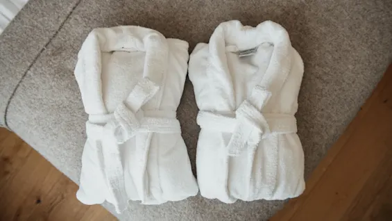 Kaksi viihtyisää valkoista kylpytakkia odottaa vieraita Home Hotel Victoriassa kutsuen rentoutumaan ja nauttimaan mukavuudesta.