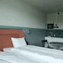 Ett modernt och funktionellt hotellrum på Stopover Hotel Falkenberg med en bekväm säng och ett kompakt pentry.