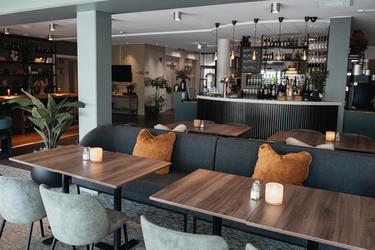 En modern och mysig restaurang- eller barinteriör, inredd för bekväm middag och umgänge, med en välutrustad bar.