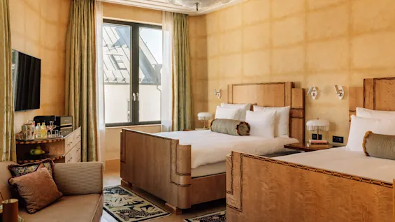Et luksuriøst hotellrom med en elegant seng, møbler og et stort vindu, som viser velstand og komfort.