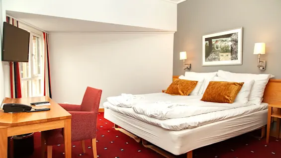 Suite at Home Hotel Bryggeparken, made bed and chair.