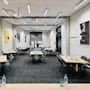 Conference room with rectangular tables, chairs, and water bottles arranged for a meeting. Motivational posters on the walls include text like "SOMETIMES YOU HAVE TO BE A BITCH TO GET THINGS DONE."