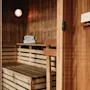 An inviting wooden sauna, ready for relaxation, with towels on a shelf.