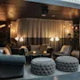 Et hyggeligt hotelloungeområde med komfortable siddepladser, varm belysning og et skilt, der peger mod Middag. Velkommen.