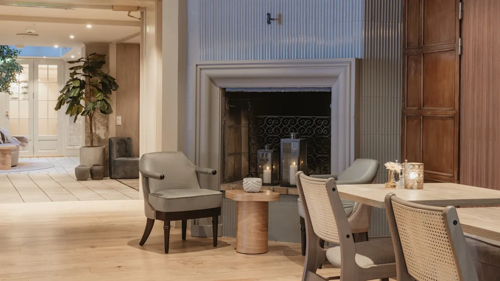 En varm och inbjudande hotellounge med öppen spis, bekväma sittplatser och mjuk belysning från levande ljus.