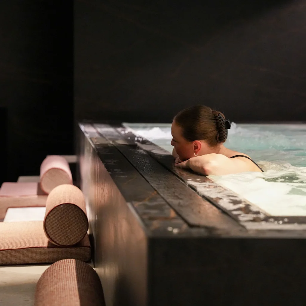 A person relaxing in a modern spa hot tub, enjoying a moment of tranquility and warmth.