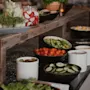 A vibrant buffet spread featuring an array of fresh vegetables and healthy ingredients in bowls and jars, ready for serving.
