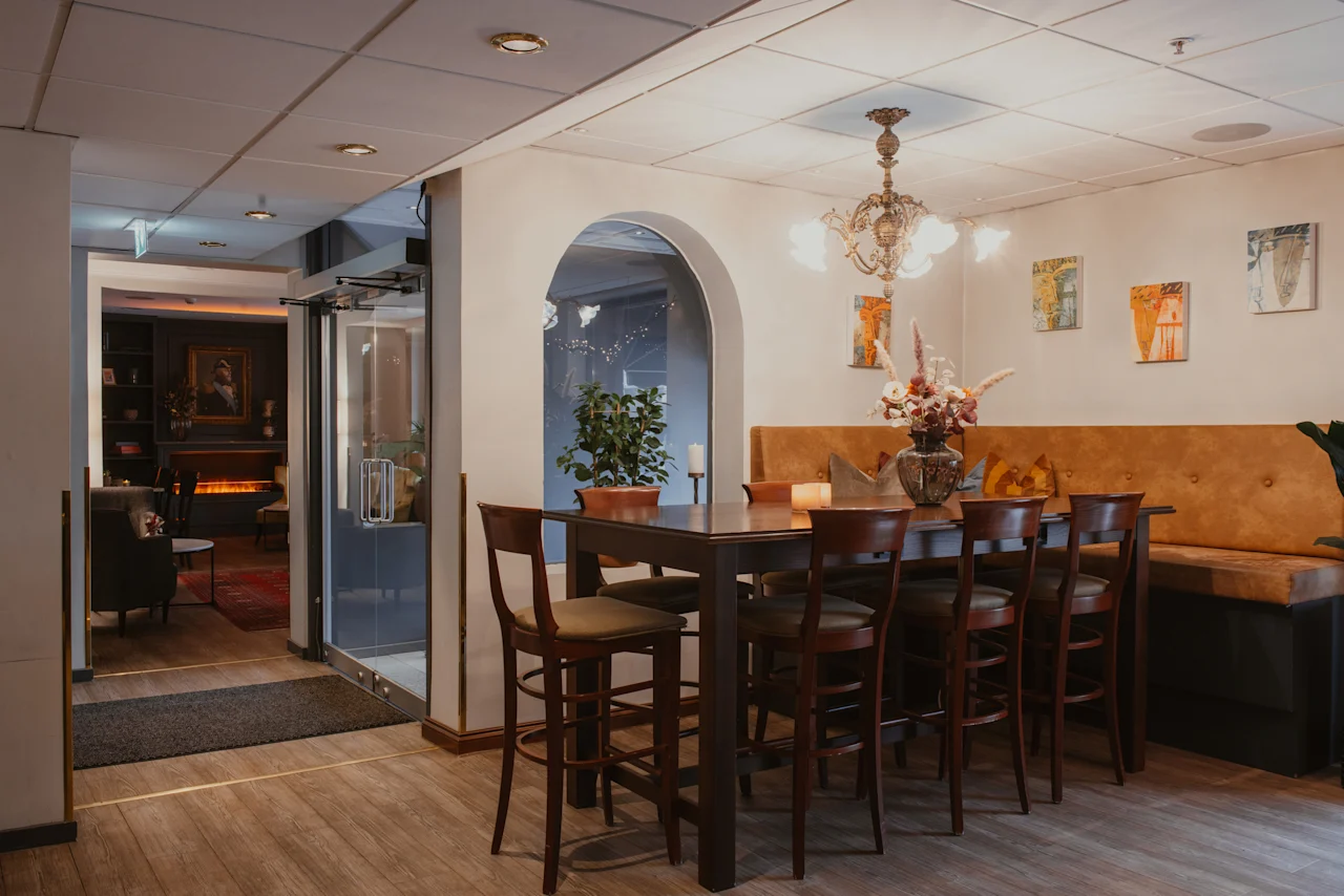 Home Hotel Kung Oscar: A welcoming hotel space featuring a communal high table and a cozy lounge area.