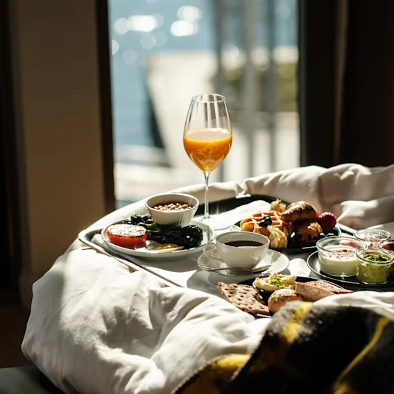 En härlig frukost på sängen med utsikt över vattnet, njut av en avkopplande morgon.
