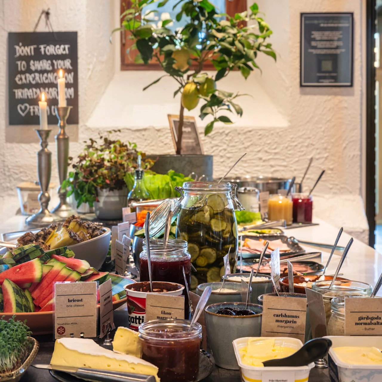 A buffet with an array of fresh food is displayed for selection, featuring labels in Swedish, within a cozy interior setting.