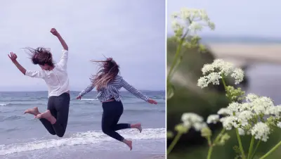 Two girls jumping next to flowers on the Sola beach