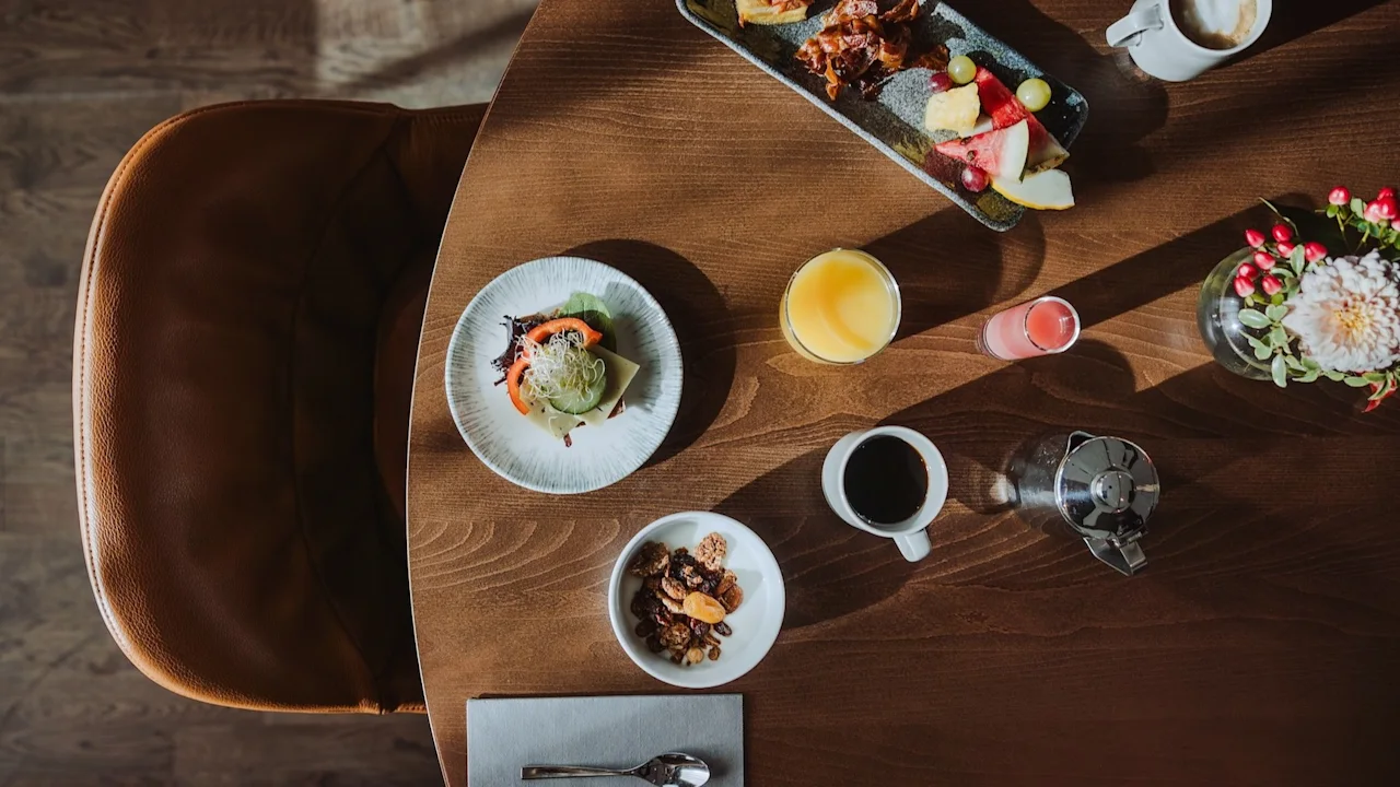 En deilig frokostbuffé på et trebord med ulike retter, juicer og kaffe, klar til å nytes.