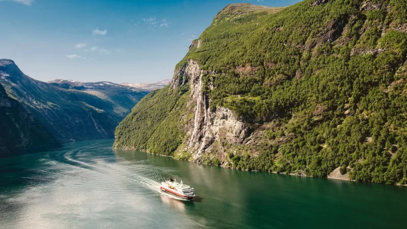 Hurtigruten ship passing by beautiful fjords in Norway