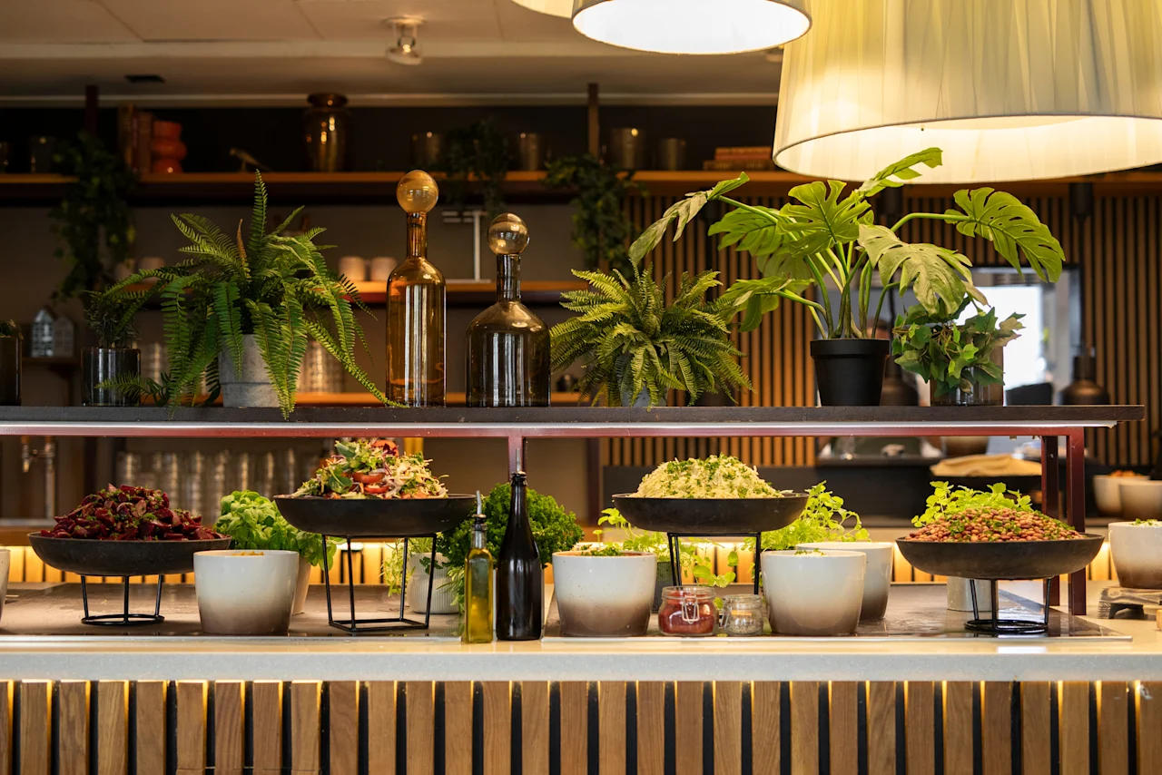 En livlig buffé på Home Hotel Tapto med fräscha sallader och gröna växter, redo för gästerna att njuta av.