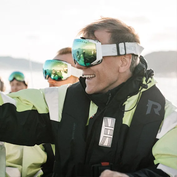 Smiling people wearing protective gear on a RIB boat during Quality Hotel kickoff.