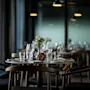 Et vakkert dekket bord i en dempet belyst restaurant, klart for gjester.