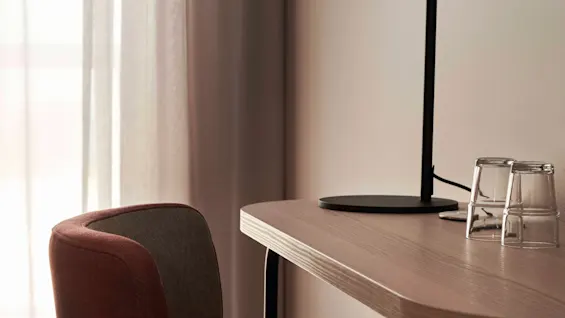 En bekväm arbetsplats med skrivbord, lampa och stol, redo att användas.