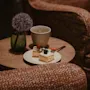 A delightful moment with cake and a hot beverage on a small table, surrounded by plush seating.