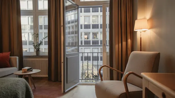 Home Hotel Wellington - Superior Twin – Et hyggeligt hotelværelse med åben altandør med udsigt til en bygade.