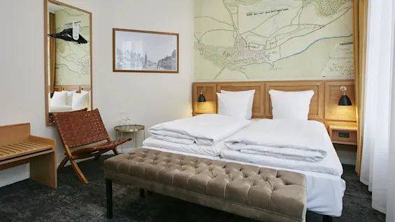 Et hyggeligt hotelværelse med en stor seng, en korttapet og komfortable møbler.