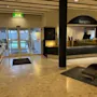 Ljus hotellobby med en reception och entredorrar i glas