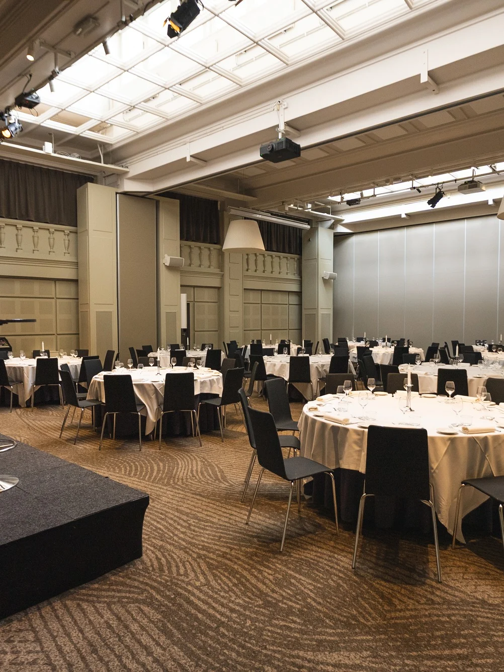 En rymlig evenemangshall på Clarion Hotel Post, möblerad med runda bord och stolar för en formell sammankomst eller konferens.