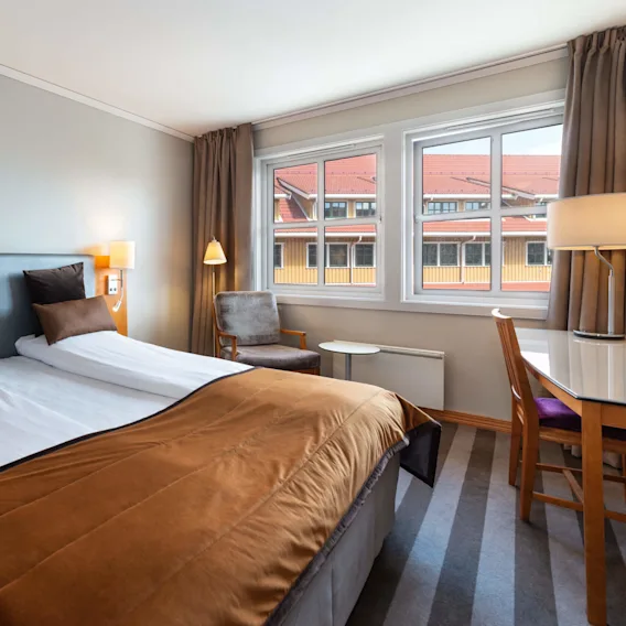 A standard double room with double bed, armchair and desk at the resort hotel Quality Hotel™ Sarpsborg in Sarpsborg, Norway. 